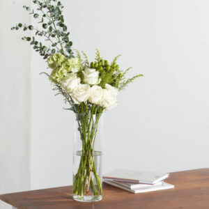 白いバラとグリーンのオリーブの枝などが花瓶に挿してある