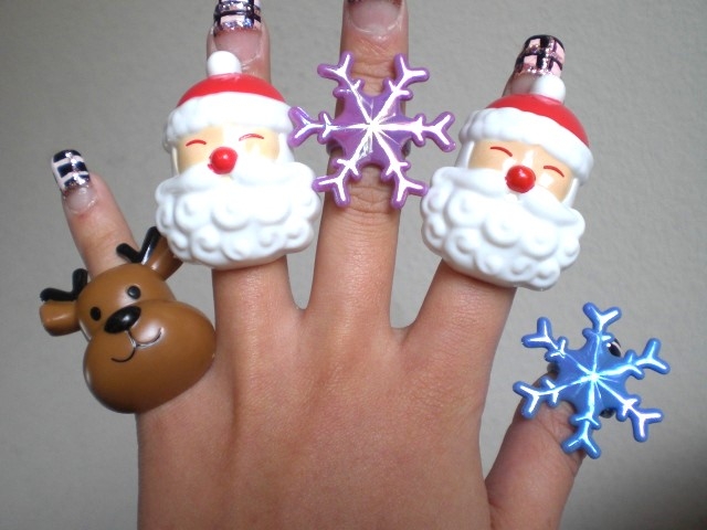 クリスマスモチーフの指輪が指に飾られている